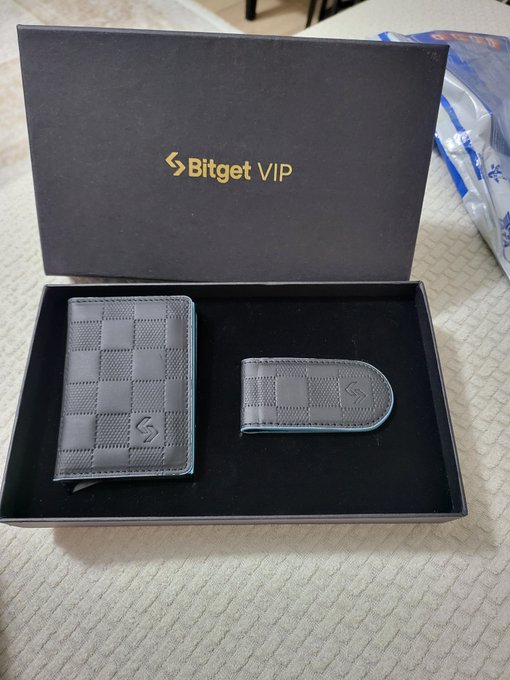 A black Bitget VIP gift box is open, displaying a matching wallet and money clip set with a checkered pattern and "S" logo. The caption highlights appreciation for the classy gift received from the Bitget Turkey team.