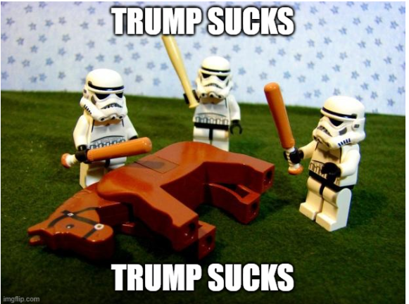 A meme featuring three Lego Star Wars stormtroopers holding orange bat-like weapons over a red Lego elephant lying on grass, with the text 'TRUMP SUCKS' overlaid at the top and bottom.