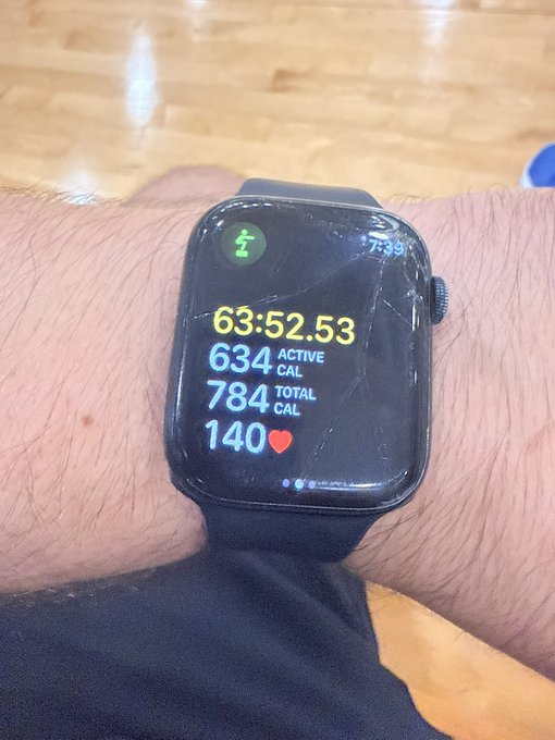 A smartwatch on a wrist shows fitness tracking metrics including '63:52.53' time, '634 ACTIVE CAL', '784 TOTAL CAL', and a heart rate of '140'.