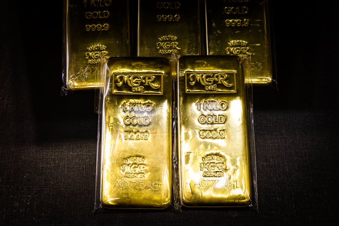 Four sealed 1-kilo "IGR ASSAY" gold bars (999.9 fineness, serial numbers 97349 and 07311) rest on dark fabric, visually reinforcing the post's claim that institutions are stockpiling physical gold as hard-asset collateral alongside digital settlement assets like XRP. The gleaming bullion serves as a tangible symbol of the tangible reserves being accumulated in response to bond-market pressure.