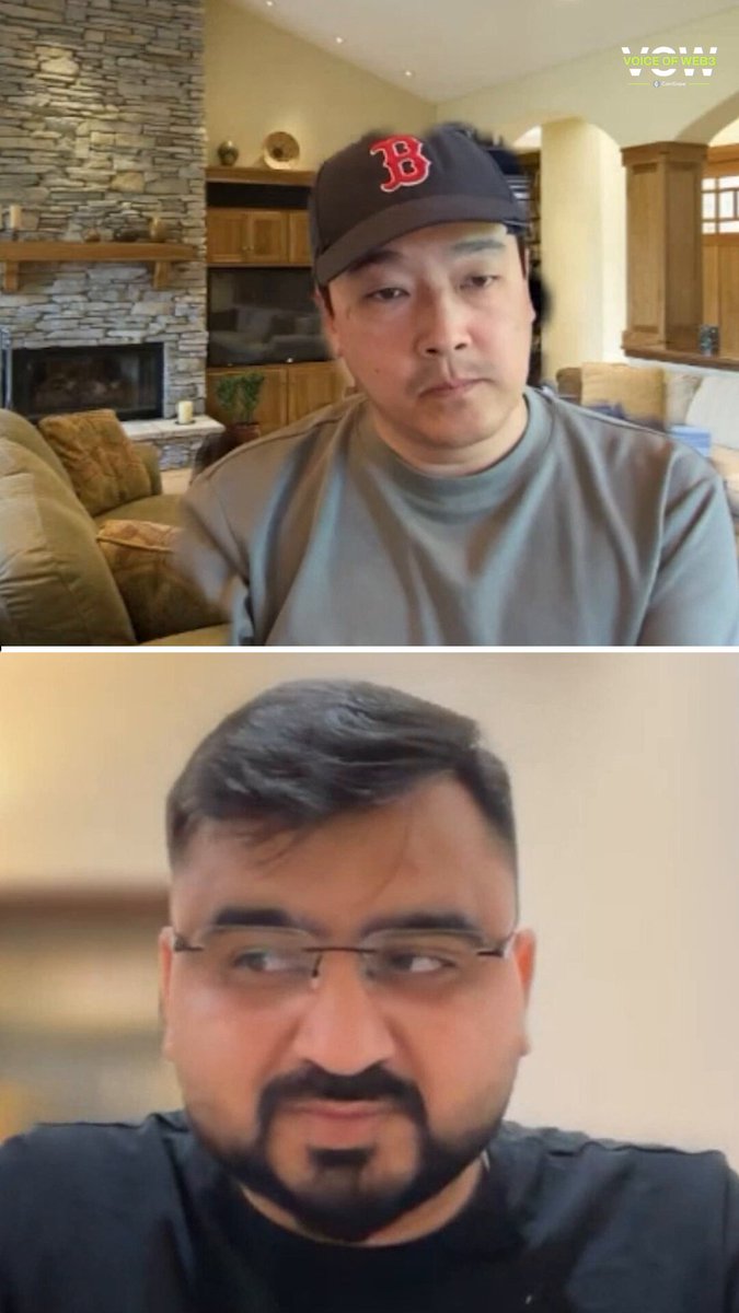 The image shows two men wearing baseball caps sitting next to each other in a room with a fireplace. One man has his head tilted back while looking at the camera, and the other man has his head turned to the side as if he's listening or observing something. The scene appears to be set up for a video call between the two men, possibly discussing topics related to baseball or their personal lives.