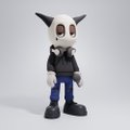 A figure or toy of a cartoonish character with a large white skull-like head, black ears, and a black outfit, standing against a white background.