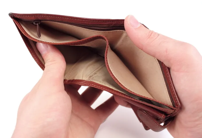 A pair of hands open a brown leather bifold wallet to reveal its empty tan interior compartments.