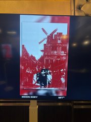 A digital artwork, “The Living Intersection of Delft,” is displayed on a monitor at NFT NYC 2026’s Edison’s Chandelier Room. The red-and-white street scene is labeled “MARNIXSTRAAT” with the number 17 visible at the bottom.