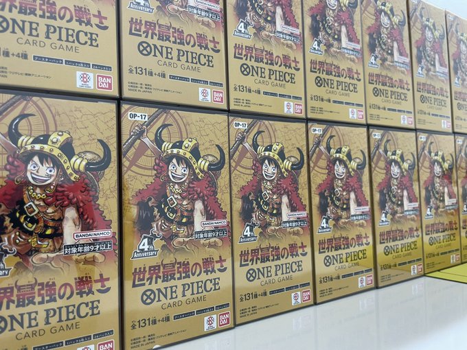 Retail display boxes of "ONE PIECE CARD GAME" featuring a 4th Anniversary character on the packaging, with Japanese text and "BANDAI NAMCO" branding.