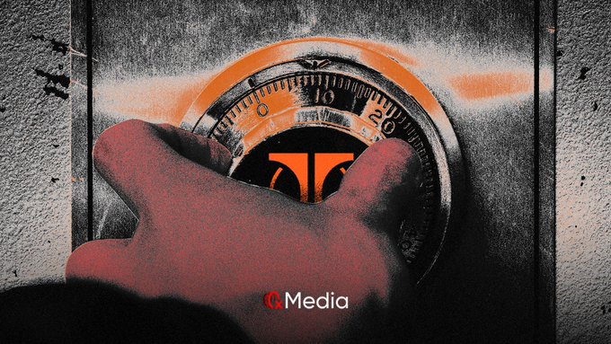 A gloved hand grips a combination lock dial on a graffiti-sprayed metal box, with a GQ Media logo visible at the bottom.