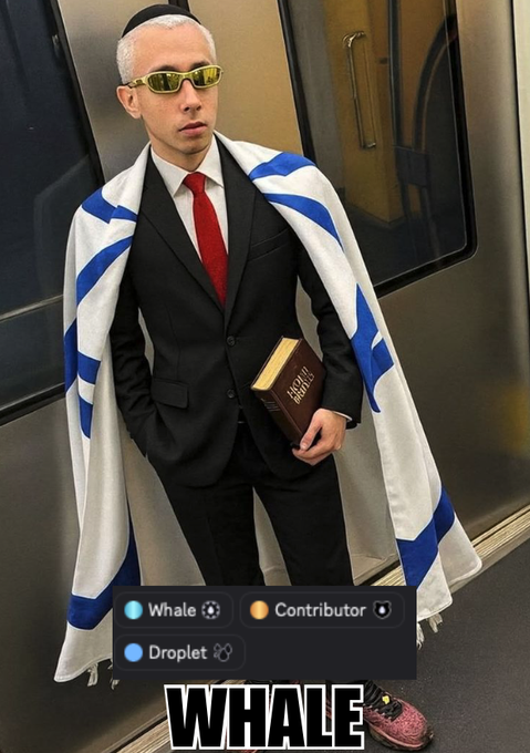 A person in a black suit, red tie, yellow sunglasses and a yarmulke wears a blue and white striped tallit and holds a Bible, labeled 'WHALE' with Whale, Droplet, and Contributor role badges.