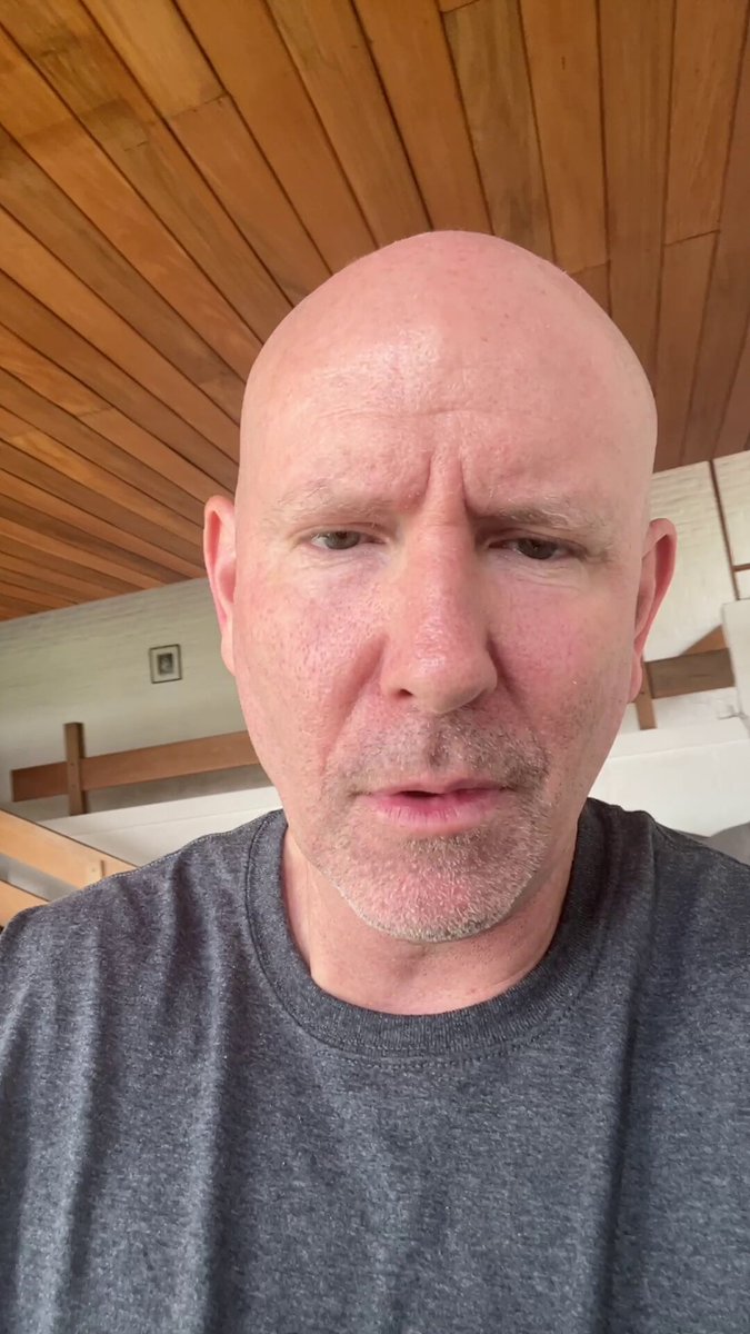 The image features a bald man wearing a gray t-shirt, looking at the camera with an intense expression. He appears to be posing for the photo, possibly for a social media platform or promotional material. The caption "Build you idea on Solana today" is written in the corner of the image, which suggests that it might be related to a product or service offered by Solana.