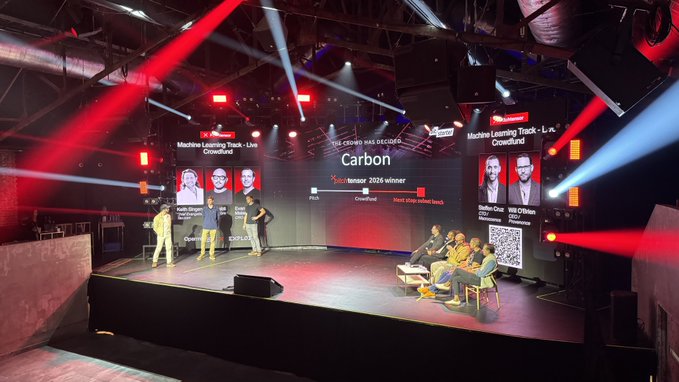 A live conference stage setup titled 'Machine Learning Track - Live Crowdland' and 'The Crowd has decided Carbon - Nemion 2025 winner', featuring presenters and panelists on a stage with red and white lighting.