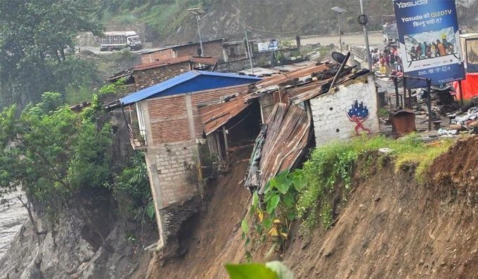 A landslide has partially collapsed a building perched on a steep hillside, exposing its damaged interior and tilting roof amid debris. A Yasuda LED TV billboard is visible in the background, while the post discusses ongoing efforts to integrate @zano_project, @freedomdollar5, and @BitcoinCashOG into a payment solution—seemingly unrelated to the disaster depicted.