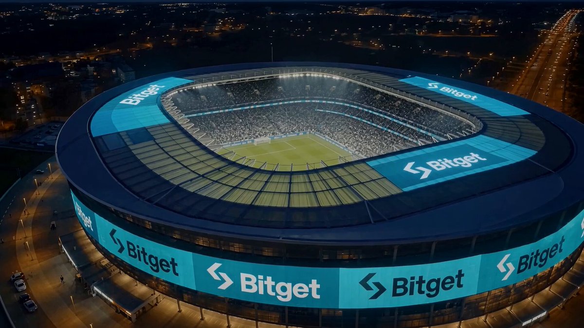 The image shows an aerial view of a large stadium at night with a blue roof. The stadium has a lot of lights, which makes it appear as if it's lit up for a nighttime event or game. There are also advertisements on the side of the building and a car parked nearby. The post about diversification suggests that investing in various assets can help protect against market fluctuations and provide stability during uncertain times. It emphasizes the importance of spreading investments across different asset classes, such as stocks, ETFs, and gold, to minimize risk and maximize returns.
