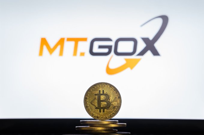 A gold Bitcoin coin is shown on stacked coins beneath the Mt. Gox logo. The image illustrates the report that 34,000 BTC worth about $2.8 billion remain with the Mt. Gox estate as its repayment deadline was extended to October 31, 2027.