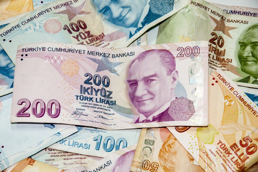 Turkish Lira banknotes featuring Mustafa Kemal Atatürk's portrait, including 200, 100, 50, and 20 lira denominations spread out.