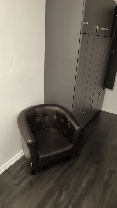 A dark brown leather tub chair sits empty in a corner next to a row of dark gray lockers on wood-look flooring. The caption fits the post's theme—the vacant "cuck chair" symbolizes crypto traders sidelined while altcoins rally without them.