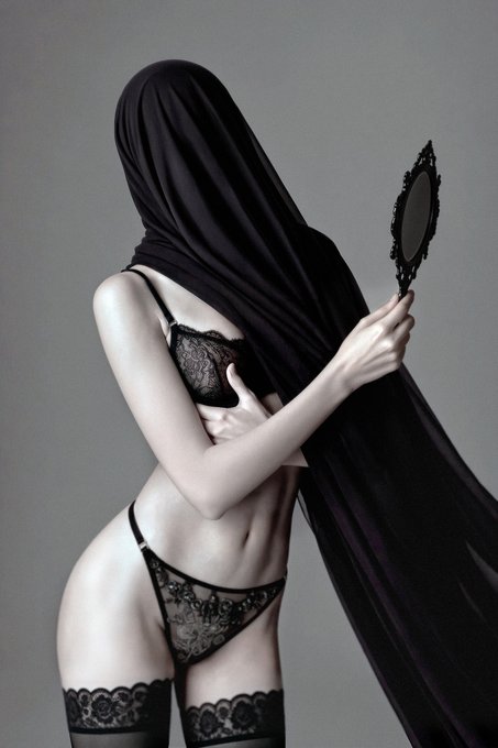 An artistic photo of a person wearing black lace lingerie and a black veil over their head, holding an ornate hand mirror.