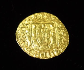 A weathered gold coin bearing the Portuguese coat of arms and the inscription "PORTVGALIAE" rests on a black background, illustrating the post's point about gold's enduring purchasing power across millennia.