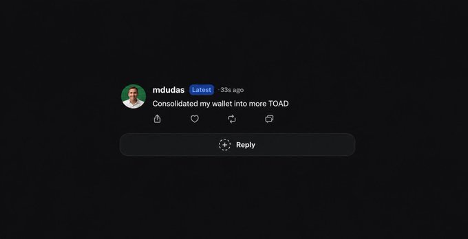 A screenshot of a social media reply with a profile picture of Michael Dudas (@mdudas), featuring his comment "Consolidated my wallet into more $TOAD" alongside engagement icons and a reply button, illustrating the accompanying post about his crypto investment in $TOAD.