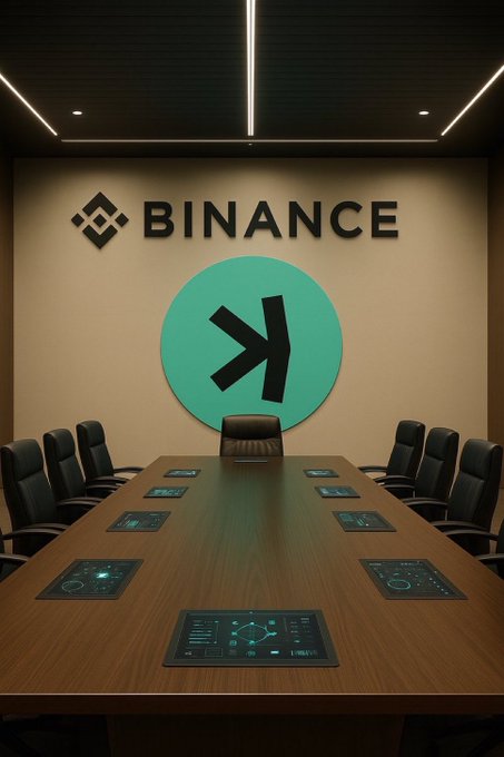 A sleek, empty corporate boardroom features a large wooden conference table lined with black chairs and embedded tablet screens, while the back wall prominently displays the "BINANCE" logo alongside its signature green circular emblem—visually reinforcing the post's discussion about waiting for a potential $KAS listing on the exchange.