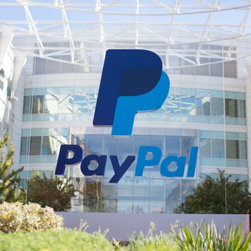 The exterior of a glass building displaying a large, prominent blue PayPal logo above its entrance.
