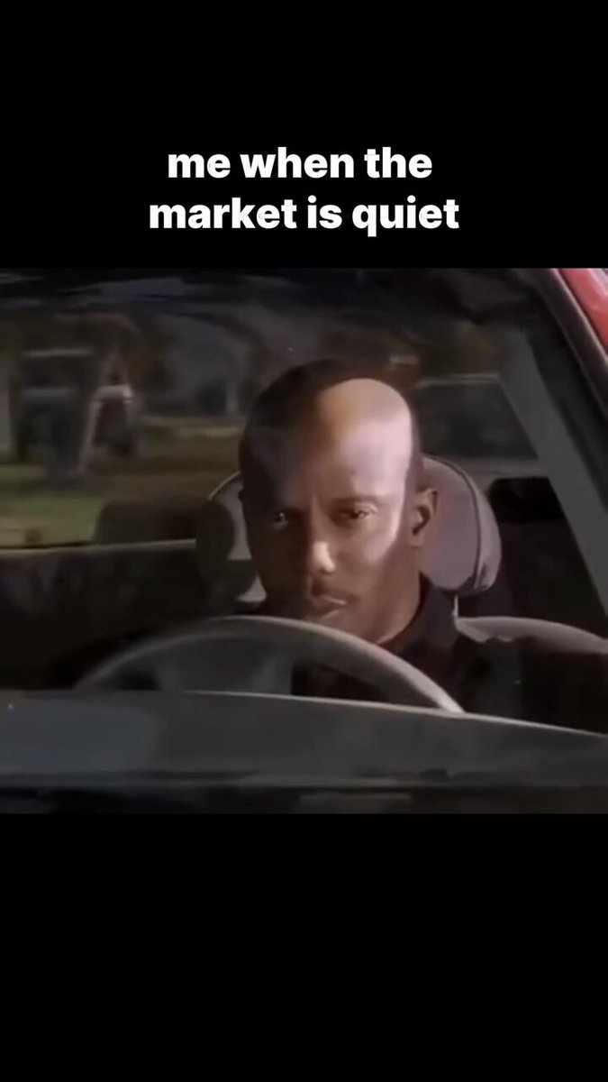The image features a man sitting inside a car, looking at his phone with an expression of confusion or surprise. The caption below the photo reads "me when the market is quiet", which seems to be a reference to the current state of the stock market. This phrase has been used in various contexts and has become somewhat of a meme or trend on social media platforms like Twitter, where it has gained popularity over time.