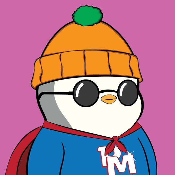 A cartoon penguin character wearing an orange beanie, round sunglasses, and a blue cape with a red tie, with 'T2M' displayed on its chest.