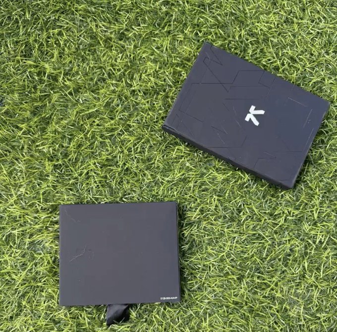 Two black electronic devices, one with a white 'X' logo and another labeled 'S-DELTA19P', rest on green artificial grass.