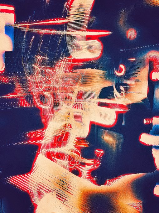 An abstract, heavily distorted image with red, white, and blue streaks creating a glitch or motion blur effect, possibly showing a stylized vehicle or machinery.