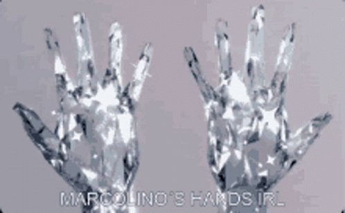 The image features two hands made of glass with a metallic sheen, placed against a gray background. The caption below the image reads "MARCOLLINO'S HANDSIRL". This suggests that the image might be related to a discussion or promotion about the brand of glass used in the creation of these unique hands.