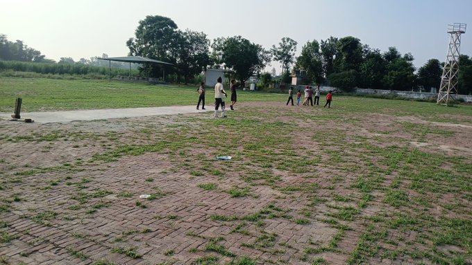 A group of children play together on a grassy, brick-paved field in what appears to be an evening outdoor setting, with a watchtower and trees visible in the background. The image illustrates simple, everyday moments of offline community life, contrasting with the post's message about BeldexCoin's mission to protect digital privacy in everyday online activities.