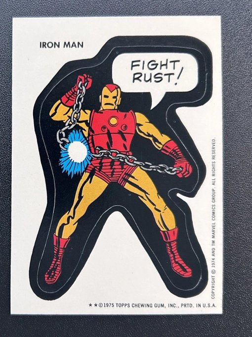 A vintage 1975 Topps Chewing Gum sticker card featuring Iron Man in a classic comic pose holding a chain, with a speech bubble saying 'FIGHT, RUST!'