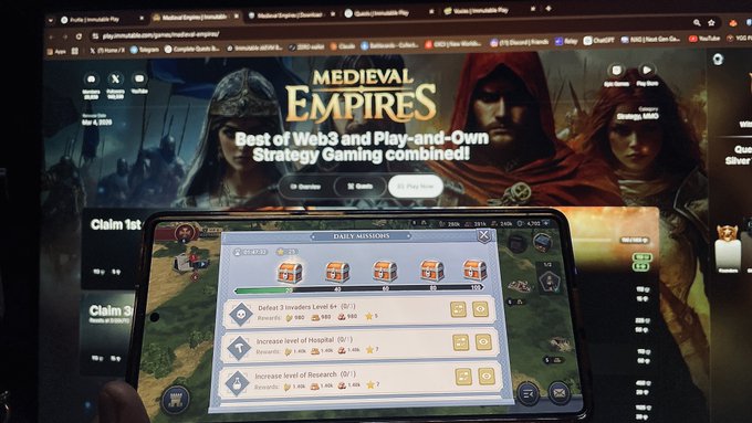 The image shows a person holding up their phone displaying a video game screen, likely Medieval Empires. The game appears to be a strategy game that combines elements of medieval warfare with modern-day gaming mechanics. The player's goal is to build and manage a kingdom while outsmarting their opponents in battle. The game offers various strategies for building and maintaining the kingdom, as well as engaging in combat against other players or enemies.