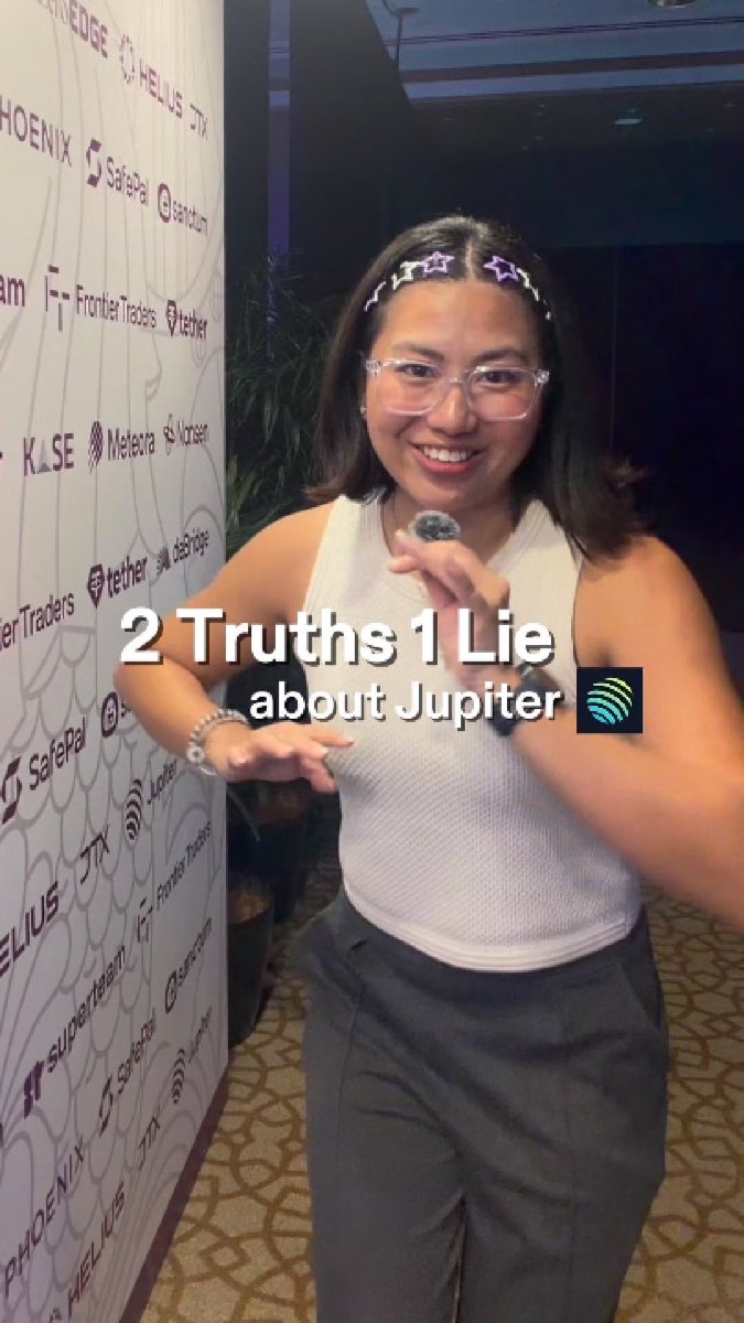 A photo of a smiling woman wearing star-shaped glasses filters and a white tank top at what appears to be a crypto event with sponsor logos (SafePal, Frontier Traders, tether, KLSE, Metedora, Vansec, JTX, Hellus, SuperValuTbank, Phoenix Labs) on the backdrop, with text reading '2 Truths 1 Lie about Jupiter'.