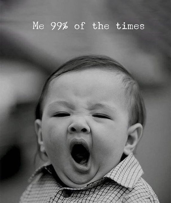A black and white photo of a yawning baby with a scrunched-up face and closed eyes, captioned "Me 99% of the times," which humorously relates to the post by depicting an exhausted or tired mood in the early morning.