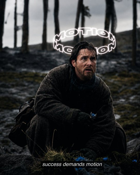 A moody photograph of a bearded man crouching in a dark forest wearing a brown coat, with a neon 'Motion Motor' sign floating above his head and the caption 'success demands motion'.