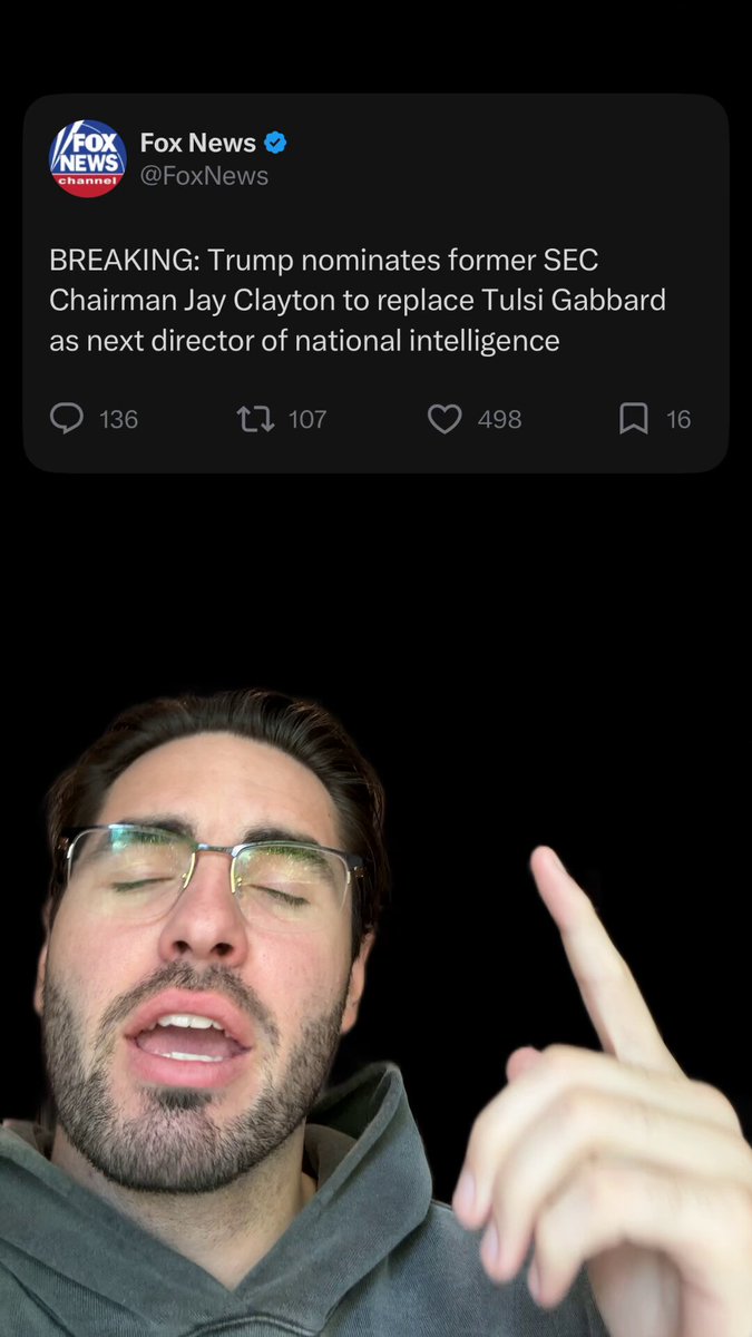 The image shows a man with glasses holding up his finger, as if he's pointing at something or making a gesture related to the post about Trump Nominating someone to lead U.S. Intelligence. The background of the image is black, which contrasts with the white text on the post and makes it stand out more prominently.