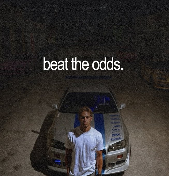A young man stands in front of a white sports car with blue racing stripes, with the motivational text 'beat the odds.' overlaid on the dark scene.