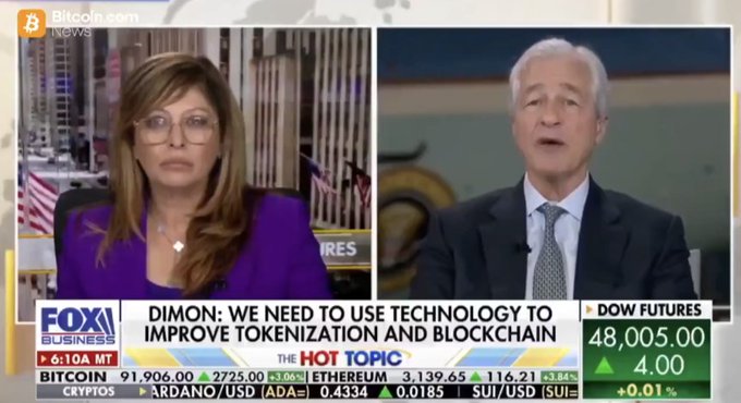 A Fox Business news split-screen shows a female host on the left and Jamie Dimon on the right, with a chyron reading 'DIMON: WE NEED TO USE TECHNOLOGY TO IMPROVE TOKENIZATION AND BLOCKCHAIN' and a ticker displaying prices for Bitcoin, Ethereum, Cardano, and SUI.