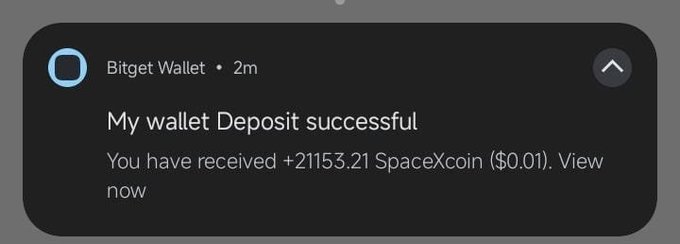 A notification from Bitget Wallet announces a successful deposit of "+21153.21 SpaceXcoin ($0.01)," likely one of many spam token airdrops flooding the user's wallet.