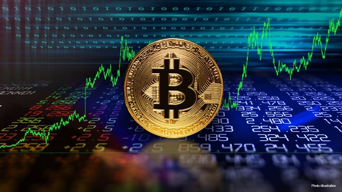 A gold Bitcoin ($BTC) coin sits against a backdrop of binary code and an upward-trending green market chart, visually illustrating the cryptocurrency's surge above $86,000 as investors reacted to weakening U.S. jobs data and diminished expectations for a Fed rate hike.