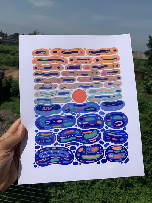 A hand holding a piece of paper with an abstract art print that features a sunset scene with a large orange sun surrounded by blue and green circles. The text "The last breath of light, held." suggests that the artwork represents the idea of the end of something beautiful or significant.