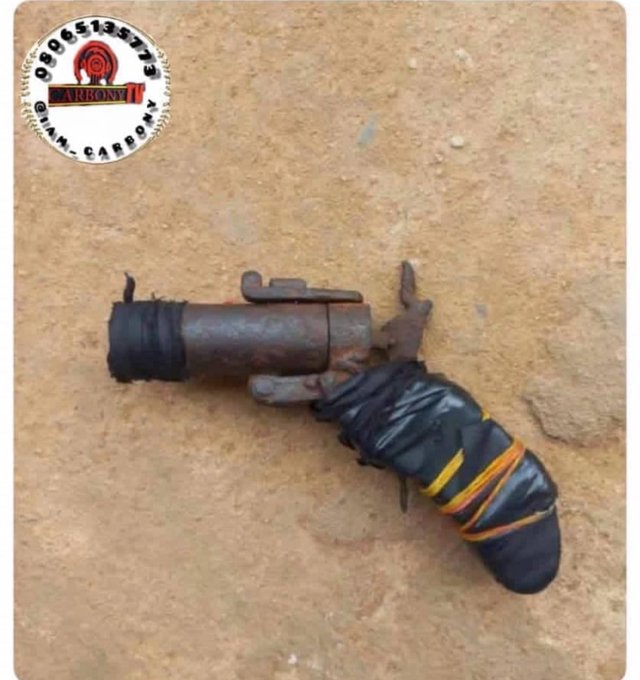 A rusty metal tool or valve component wrapped in black tape with yellow and orange accents, photographed on a tan surface with an 'ARBONY' watermark.