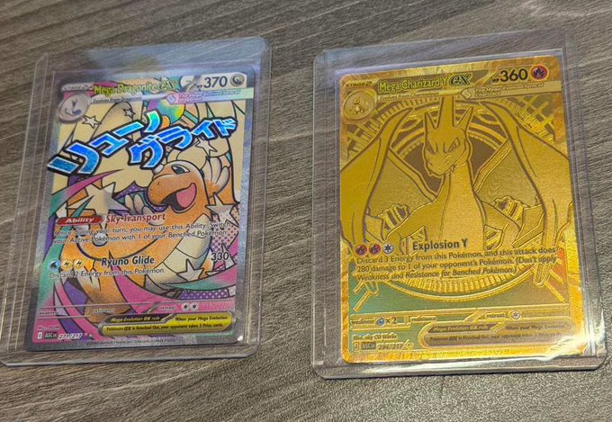 The image features two Pokemon cards, one gold colored and one silver colored, both of which are displayed on clear plastic sleeves. The gold card has a dragon design on it, while the silver card also has a dragon design. Both cards have text written on them in Japanese, indicating that they are from Japan.
