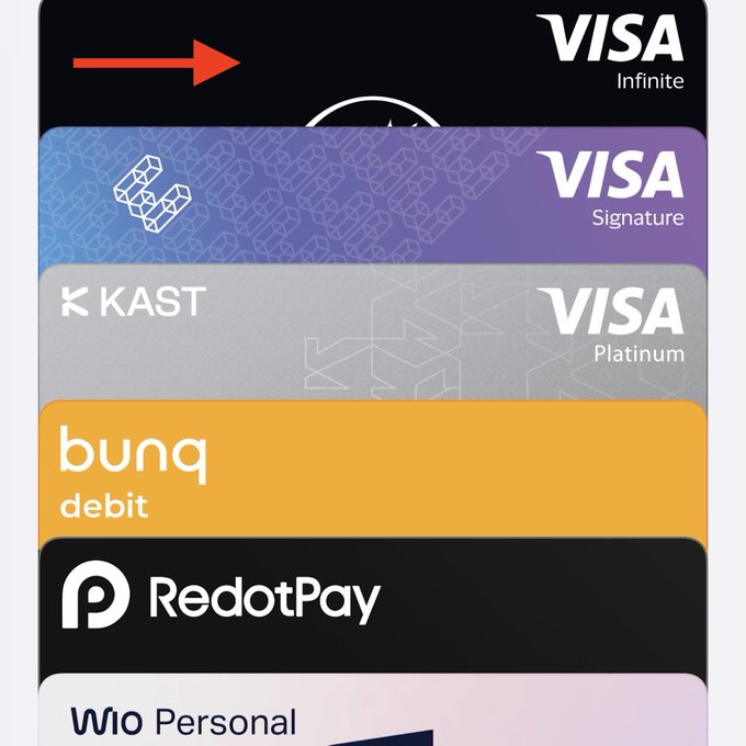A stack of crypto debit cards including Visa Infinite, Visa Signature, KAST Visa Platinum, bunq debit, RedotPay, and WIO Personal, with a red arrow pointing to the top card. The image illustrates the variety of crypto card options that were reviewed in the post, highlighting the shift toward using MotoCard over alternatives like KAST, RedotPay, EtherFi, and WioBank.