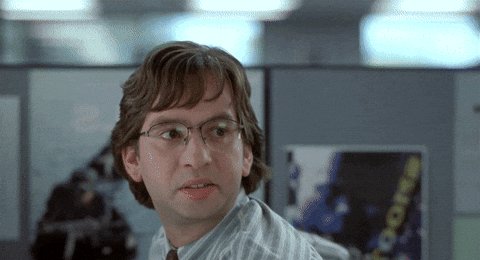 A man in a striped shirt and glasses looks sideways with a skeptical, suspicious expression in what appears to be an office setting. The image humorously captures the cautious, "I have questions" vibe of the post, as the character seems to be eyeing the ticker $ASTEROID warily while the group chat "starts acting weird."