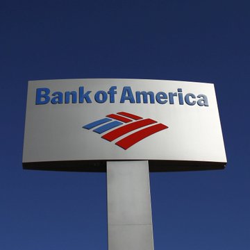 A Bank of America sign stands against a clear blue sky, displaying the company's name and its red and blue flag logo. The image visually reinforces the post's announcement about the bank expanding its cryptocurrency division, highlighting how a major traditional financial institution is making a strategic move into digital assets.