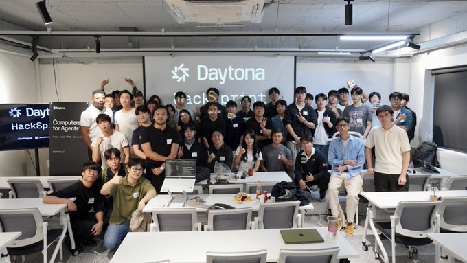 A group photo of participants at the 'Daytona HackSprinter' event, a hackathon for agents, posing in a classroom-like setting.