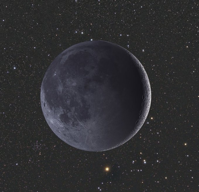 A photograph of a waning crescent moon set against a starry night sky.