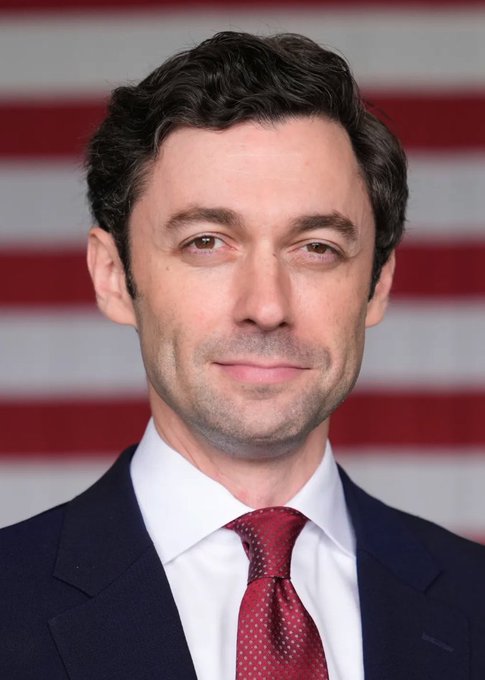 A man in a dark suit with a red tie and white shirt stands in front of an American flag backdrop, looking directly at the camera with a neutral expression. The image accompanies a post discussing Jon Ossoff's rising presence on prediction markets, where his name is highlighted as a potential Democratic candidate drawing broader appeal for the 2028 presidential race.