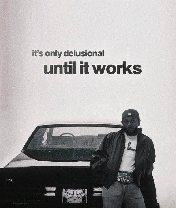 A black and white image of a man wearing a cap and leather jacket standing in front of a car, with the text 'it's only delusional until it works' displayed above.