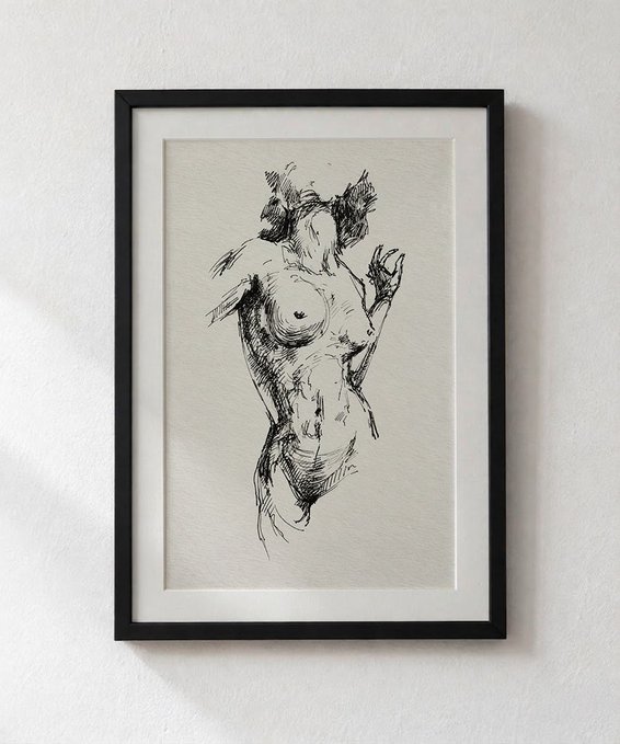 A black ink sketch of a female figure in a framed print, mounted on a plain wall.